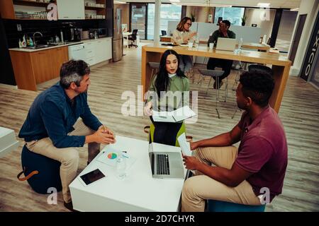 Diversi team di partner si riuniscono per discutere il lavoro per la settimana prima della riunione in sala conferenze con manager e. colleghi Foto Stock