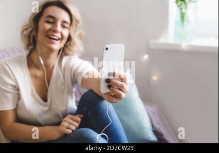 un blogger ragazza giovane comunica con i suoi abbonati seduti a. casa sul divano in un'atmosfera accogliente Foto Stock