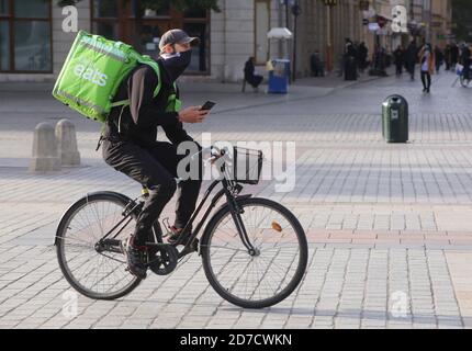 Cracovia. Cracovia. Polonia. Seconda ondata di pandemia di coronavirus. Le restrizioni sono ritornate. Corriere per la consegna di cibo in bicicletta. Foto Stock