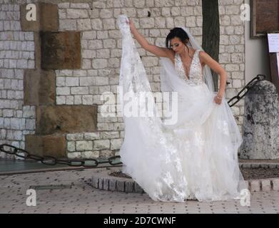 Cracovia. Cracovia. Polonia. Giovane donna che indossa abito da sposa che si prepara per una sessione fotografica all'aperto. Foto Stock