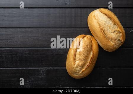 Due mini baguette francesi sul tavolo nero. Vista dall'alto. Foto Stock