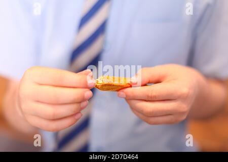 Bambino che disimballa la strada di qualità Toffee Finger cioccolato dolce avvolto in involucro, primo piano Foto Stock