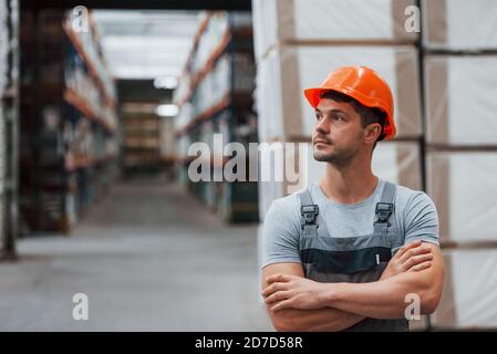 Ritratto di giovane lavoratore in uniform che è in magazzino Foto Stock