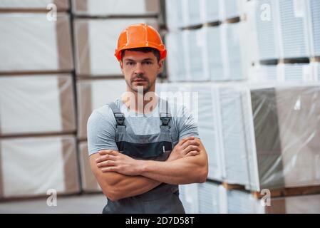 Ritratto di giovane lavoratore in uniform che è in magazzino Foto Stock