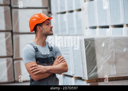 Ritratto di giovane lavoratore in uniform che è in magazzino Foto Stock