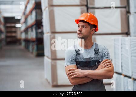 Ritratto di giovane lavoratore in uniform che è in magazzino Foto Stock