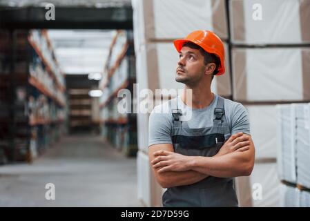 Ritratto di giovane lavoratore in uniform che è in magazzino Foto Stock