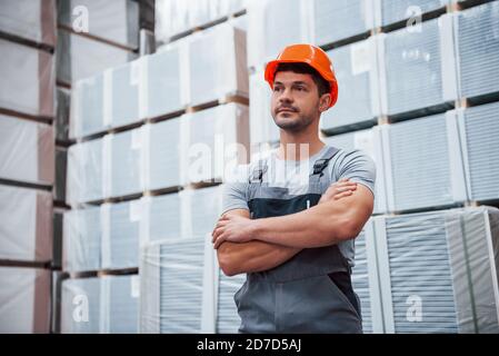 Ritratto di giovane lavoratore in uniform che è in magazzino Foto Stock