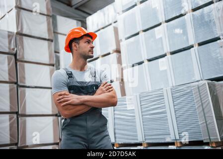 Ritratto di giovane lavoratore in uniform che è in magazzino Foto Stock