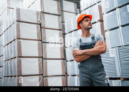 Ritratto di giovane lavoratore in uniform che è in magazzino Foto Stock