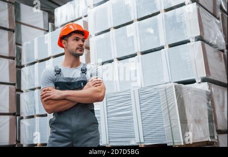 Ritratto di giovane lavoratore in uniform che è in magazzino Foto Stock