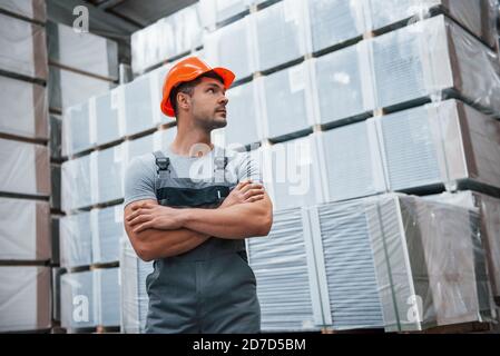 Ritratto di giovane lavoratore in uniform che è in magazzino Foto Stock