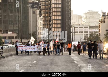 Beirut, Libano, 17 ottobre 2020. I manifestanti anti anti anti-governativi marciano dal centro di Beirut verso un'autostrada di fronte al luogo di scoppio per celebrare l'anniversario della Thawra libanese, un anno dopo l'inizio delle proteste il 17 ottobre 2019 Foto Stock