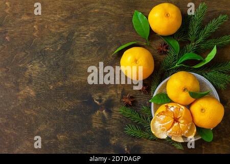 Frutta invernale. Freschi e succosi mandarini clementini con foglie su rustico tavolo di legno. Vista dall'alto sfondo piatto. Spazio di copia. Foto Stock