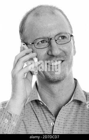 Faccia di happy businessman sorridente mentre parlano al telefono cellulare e di pensiero Foto Stock