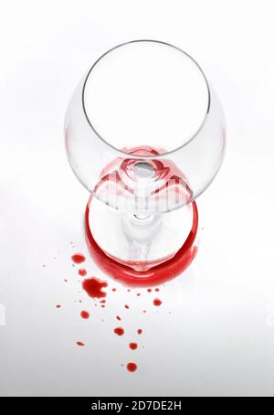 Vista dall'alto con messa a fuoco superficiale di un bicchiere di vino vuoto e. macchie di vino Foto Stock