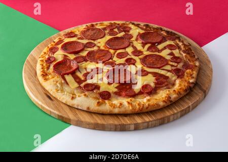 Pizza pepperoni italiana su rosso, verde e bianco Foto Stock