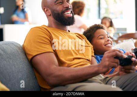 Padre e Figlio afroamericano seduto sul divano a casa Giocare a videogioco insieme Foto Stock