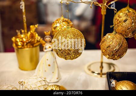 Decorazioni natalizie - palline con glitter oro alla fiera. Foto Stock