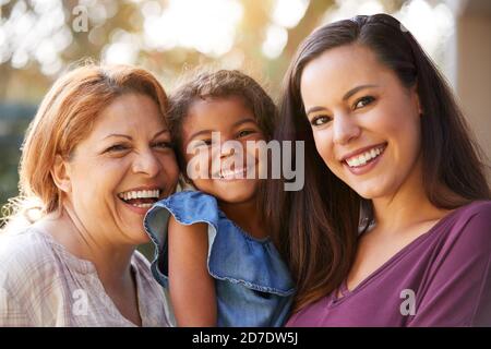 Ritratto della Famiglia ispanica femminile Multi-Generation in Giardino sorridente a. Fotocamera Foto Stock