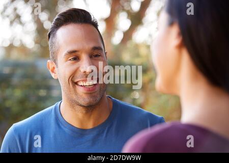 Sorridente coppia ispanica che parla e Laughing in Garden a casa Foto Stock