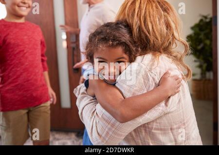 Nonni saluto nipoti alla porta anteriore come vengono a. Visita Foto Stock