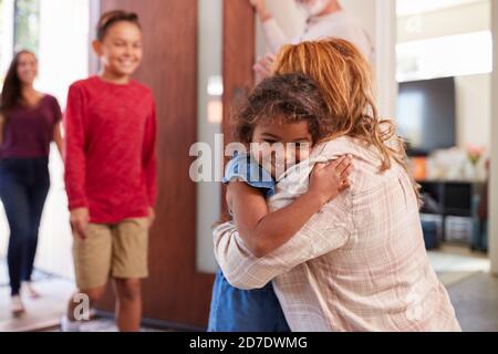 Nonni saluto nipoti alla porta anteriore come vengono a. Visita Foto Stock