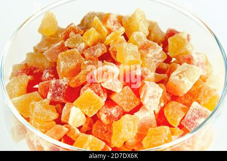 Primo piano parti di colore arancione e giallo di frutta tropicale secca nel recipiente di vetro Foto Stock