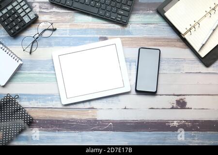 tablet digitale, smartphone e stazionate su sfondo in legno Foto Stock