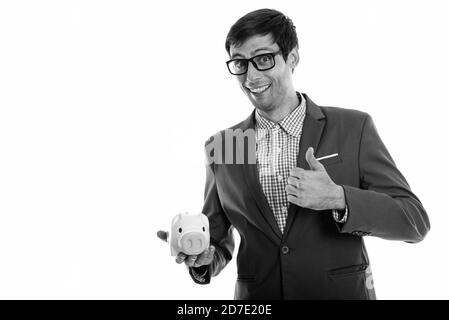 Studio shot di giovani happy businessman sorridere mentre dando pollice in alto e tenendo premuto salvadanaio Foto Stock