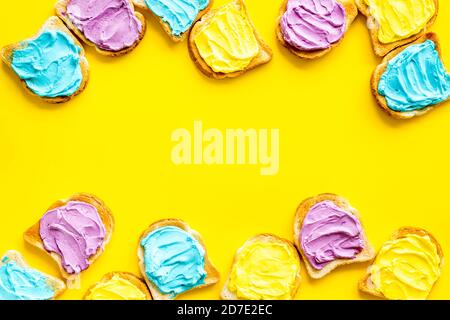 Divertente pane tostato con formaggio colorato spalmato. Vista dall'alto Foto Stock