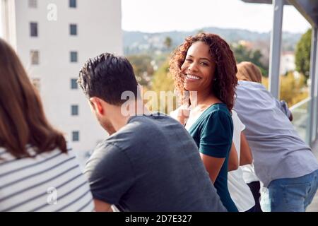 Il team aziendale si trova sulla terrazza all'aperto con vista sullo skyline della città Foto Stock