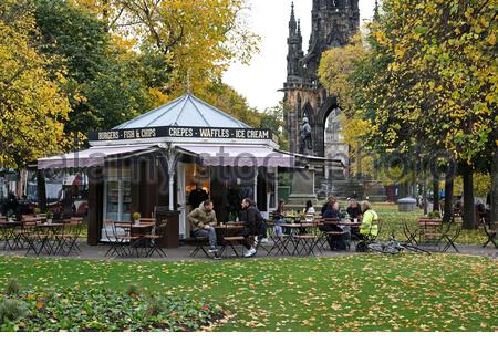 Edimburgo, Scozia, Regno Unito. 22 ottobre 2020. Tra le foglie autunnali, la gente gode di un caffè all'aperto e chiacchiera al chiosco del Cafe in East Princes Street Gardens. Credit: Craig Brown/Alamy Live News Foto Stock