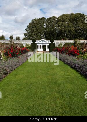 Confine erbaceo e serra. The Walled Garden, Houghton Hall & Gardens, Norfolk, East Anglia, Inghilterra, Regno Unito. Foto Stock