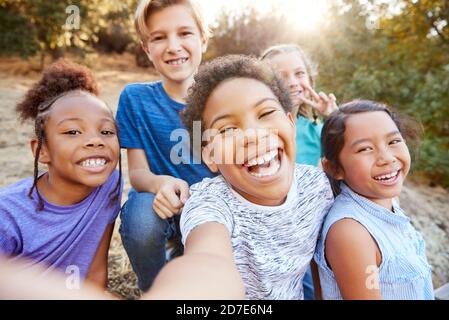 POV colpo di multi-culturale bambini in posa per selfie con gli amici In campagna insieme Foto Stock