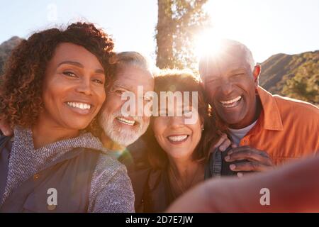 POV Shot di anziani amici che posano per Selfie come loro Escursione lungo il sentiero in campagna insieme Foto Stock