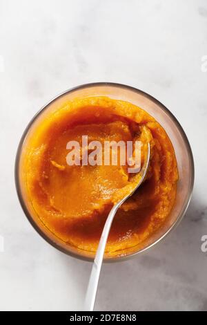 purea di zucca al forno in una ciotola di vetro su un marmo tabella Foto Stock