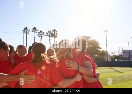 Womens Football Team in Huddle avere Motivational Pep Talk prima Partita di calcio Foto Stock