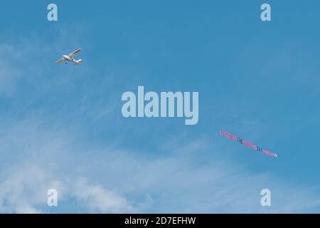 Piccolo piano Cessna skywriting, tirando standard lettera banner 'membro il giorno del Sabbath' messaggio cristiano Foto Stock