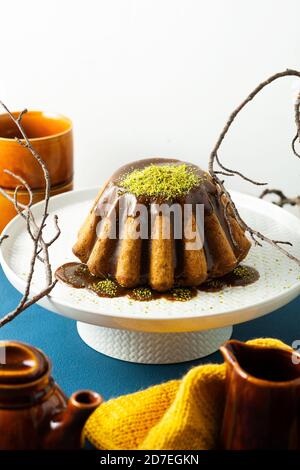 torta di zucca d'autunno con semi di papavero fritti e caramello su un piatto bianco con pistacchio Foto Stock