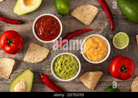 Salse messicane tradizionali. Guacamole, salsa al peperoncino e salsa al formaggio su tavola di legno Foto Stock