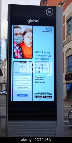 Covid 19 o insegne e pubblicità di coronavirus a Manchester, Greater Manchester, Inghilterra, Regno Unito. Un segno illuminato spinge le persone a controllare i loro sintomi per i segni del virus. Foto Stock
