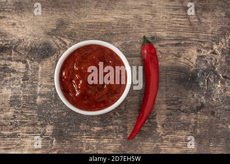 Salsa al peperoncino su tavolo di legno Foto Stock