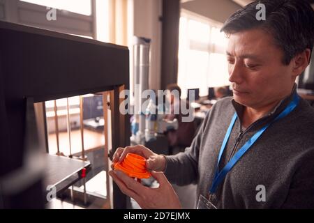 Studente Male College maturo che studia ingegneria utilizzando la macchina di stampa 3D Foto Stock