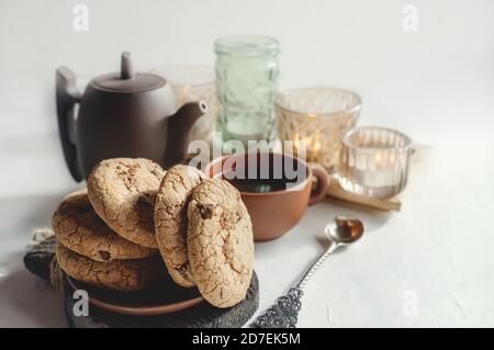 Biscotti fatti in casa di mandorle e cioccolato sulla tavola con un Tazza di tè in ceramica e bollitore Foto Stock