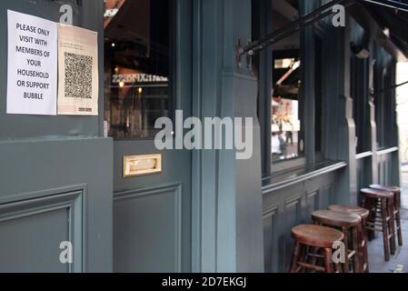 Segnaletica al di fuori di un bar che consiglia ai clienti di visitare solo con le loro bolle domestiche nel centro di Londra, Regno Unito, il 22 ottobre 2020. Oggi il Cancelliere britannico dello scacchiere Rishi Sunak ha annunciato un nuovo pacchetto di sostegno per le imprese colpite dalle restrizioni del secondo livello di allerta, tra cui Londra, che comprende sovvenzioni per pub, bar e ristoranti. Ciò viene come il segretario di salute Matt Hancock ha annunciato che Stoke-on-Trent, Coventry e Slough si sarebbero spostati nel livello 2 da sabato in risposta ai 19 casi crescenti di Covid. (Foto di Claire Doherty/Sipa USA) Foto Stock