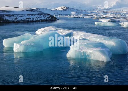 jokulsarlon laguna in Islanda in inverno in un sole giornata con un iceberg in primo piano e picchi innevati sfondo Foto Stock