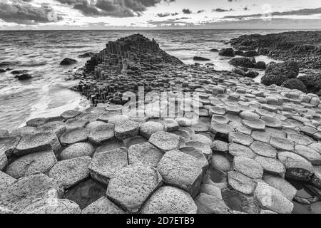 Tramonto al Selciato del Gigante, un sito patrimonio dell'umanità dell'UNESCO con circa 40,000 colonne esagonali sulla costa di Antrim, nell'Irlanda del Nord. Foto Stock