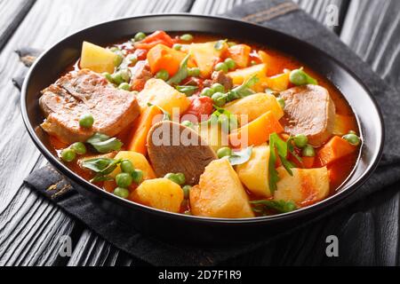 Zuppa profumata di pomodoro a base di lingua di manzo con verdure da vicino in una ciotola sul tavolo. Orizzontale Foto Stock