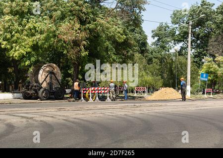 Odessa, Ucraina - 8 agosto 2019: I lavoratori tirano un rotolo di linea di cavo ad alta tensione Foto Stock